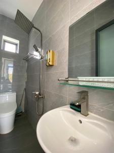 永熙Hotel Vũng Găng的浴室配有盥洗盆和带镜子的淋浴