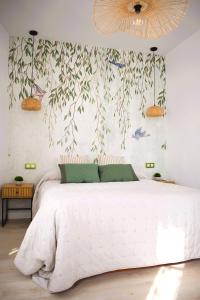 曼萨纳雷斯Casa Rístori Fábrica de Harinas的卧室配有白色的床,墙上有鸟儿