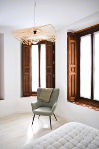 曼萨纳雷斯Casa Rístori Fábrica de Harinas的一间卧室配有椅子和吊灯