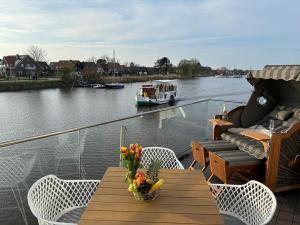 卡罗利嫩西尔Seeperle Meerleben的阳台配有桌椅,河上设有船只
