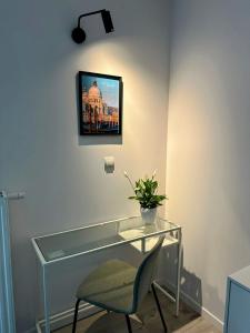 弗罗茨瓦夫Mikro Aparty bezpłatny parking的一张玻璃桌子、椅子和墙上的照片