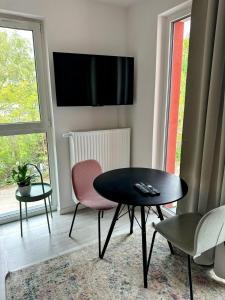 弗罗茨瓦夫Mikro Aparty bezpłatny parking的客厅配有桌椅和电视。