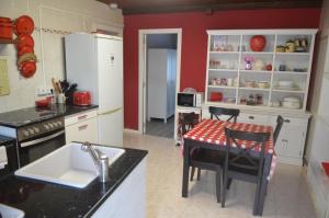 卢阿尔卡La Casina de Luarca的厨房配有白色橱柜和桌椅