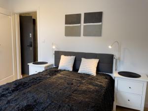 霍茹夫URBAN APARTMENTS Premium No 3 Chorzów Katowice, FREE PRIVATE PARKING的一间卧室配有一张大床和两个白色橱柜