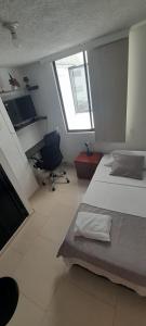 布卡拉曼加habitación con baño en bucaramanga-cerca sena-uis的一间卧室配有两张床、一张桌子和一把椅子