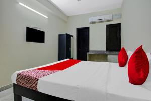 新德里OYO Flagship Hotel B K Palace的卧室配有带红色枕头的白色床