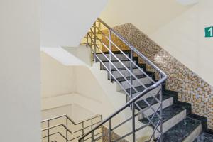 新德里OYO Flagship Hotel B K Palace的带有金属栏杆和砖墙的楼梯