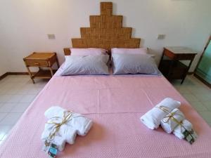 弗雷杰内Vacanze degli Sposi的一间卧室配有粉红色的床和毛巾