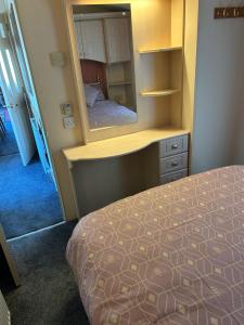 LlangristiolusHideout caravan的一间卧室配有一张床和一面大镜子