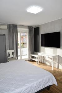 拉蒂纳La Maison Latina Guest House的卧室配有白色的床和平面电视。