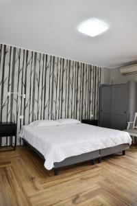 拉蒂纳La Maison Latina Guest House的一间卧室配有一张床和条纹墙