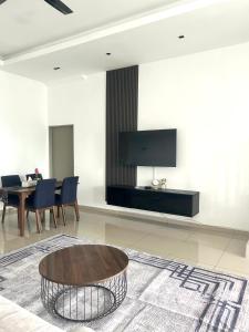 而连突Homestay Taman Melati Jerantut的客厅配有桌子,墙上配有电视