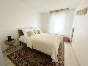 斯特拉斯堡Robertsau, jardin en ville的一间白色卧室,配有床和地毯