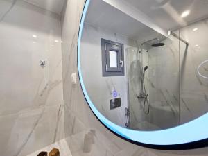 马拉松坎博斯Sunrise Limnionas Apartments的带淋浴和大镜子的浴室