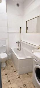 什切青Apartamenty Magvel Gold的带浴缸、卫生间和盥洗盆的浴室
