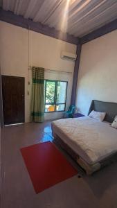TelukdalemTaman Baloho Indah - Hotel & Resort的一间卧室设有一张床和一个大窗户