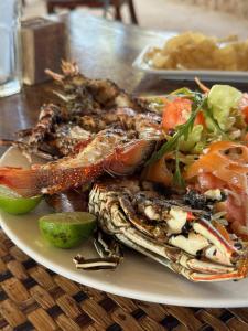 吉汶瓦Kiwengwa Bungalow Boutique Resort的桌上一盘带螃蟹和蔬菜的食物
