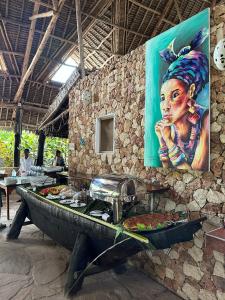 吉汶瓦Kiwengwa Bungalow Boutique Resort的一张餐桌,上面有一幅女人的画