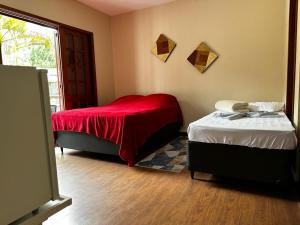 彼得罗波利斯Village Hostel的一间卧室配有两张床和红色毯子
