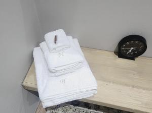 帕尔Hanepoot 503的一堆毛巾放在钟表旁边的桌子上