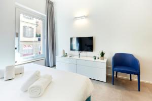 米兰Suite Meravigli - Incredibile posizione DUOMO e CASTELLO的一间白色卧室,配有电视和蓝椅