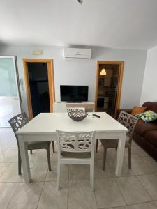 波利科罗Appartamento in Villa a Policoro的客厅配有白色的桌椅