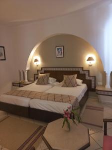 哈马马特Tunisia Lodge的一间卧室配有一张大床,上面有拱门