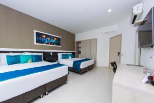 卡塔赫纳瓦拉纳西机场精品酒店的一间酒店客房,设有两张床和电视