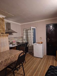 库塔伊西Lux-2-or-1- persons Irodion Edoshvili Street #15的客厅设有厨房、桌子和冰箱。