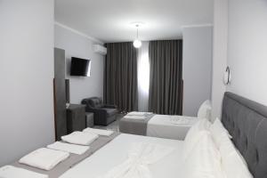 克鲁亚Hotel DEAL -Castle View Rooms的白色卧室配有床、沙发和椅子