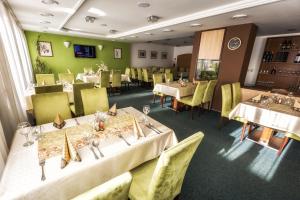鲁容贝罗克Hotel Malina***的餐厅设有白色的桌子和黄色的椅子