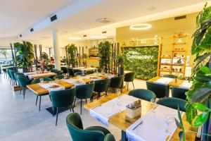 GarčinRanč Ramarin的餐厅设有木桌和绿色椅子