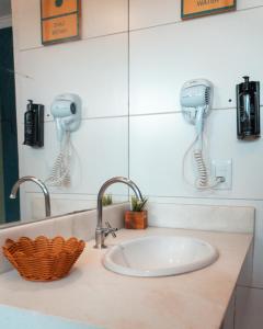 博尼图Selina Bonito的浴室水槽和墙上的2个吹风机