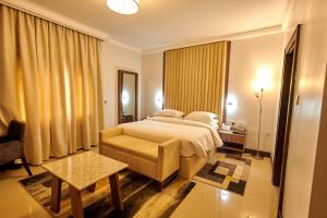阿布贾MEETHAQ HOTELS MAITAMA的一间卧室配有一张床、一把椅子和一张桌子