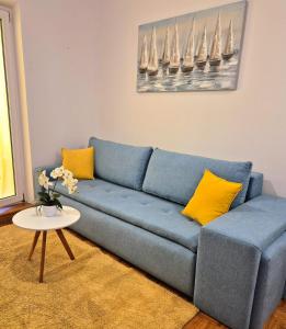 塞尔瑟Apartman Lopar Selce的客厅里配有带黄色枕头的蓝色沙发