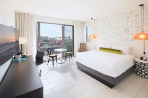 洛杉矶Hotel Erwin Venice Beach的酒店客房带一张床、一张桌子和椅子
