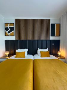 塔维拉Hotel Don Rodrigues的一间卧室配有两张带黄色枕头的床