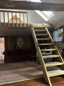 CrowhurstQuirky Barn Conversion Crowhurst Battle的带沙发的客房内的一张带楼梯的阁楼床
