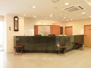 滨松Centurion Hotel Hamamatsu的大楼内带柜台和椅子的等候室