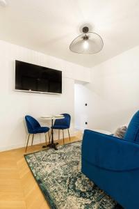 巴黎Chic Apartment in the Prestigious Saint Honoré的客厅配有蓝色的沙发和桌子