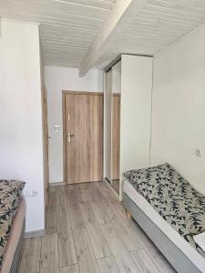 MiałkówekAGRO-Jabłońscy的一间卧室设有两张床,铺有木地板