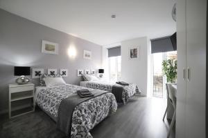 波尔图Guest House Triunfo的酒店客房设有两张床和窗户。