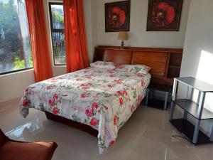 乌旺戈海滩3 Queensway Uvongo的一间卧室配有一张带花卉床罩的床