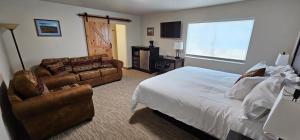 Eagle RiverEagle River Lodge的一间卧室配有一张床、一张沙发和一张书桌