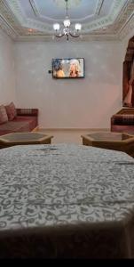 تجزئة القلم حي أطلس بني ملال的客厅配有沙发和墙上的电视