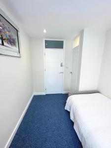 伦敦3 Bedroom Home In London - Lee - By Atleys Homes的卧室配有白色的床和蓝色地毯