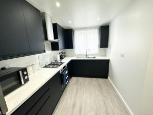 伦敦3 Bedroom Home In London - Lee - By Atleys Homes的厨房配有黑白台面和水槽