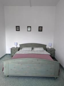 比克Éden Panzio的一间卧室配有木床和2个床头柜
