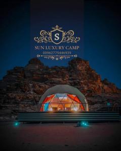 瓦迪拉姆SUN LUXURY CAMP &Tour的建筑前的长凳,有标志