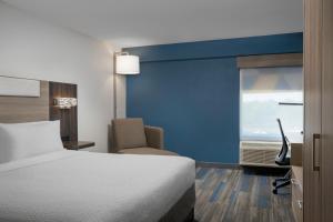 林夕昆高地巴尔蒂摩快捷智选假日酒店-BWI北机场的客房设有床、椅子和窗户。